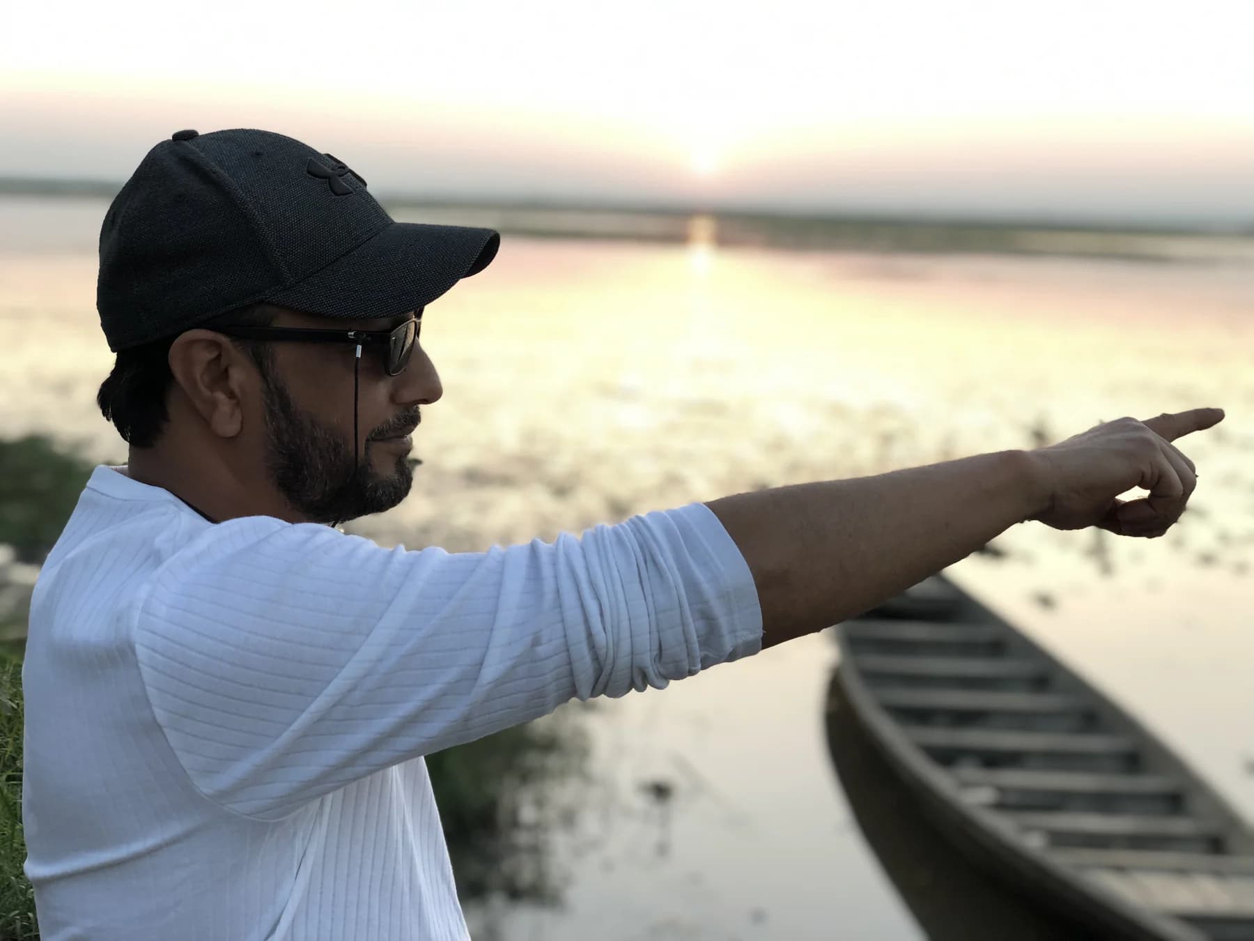 Shab looking across the river beside a wooden boat